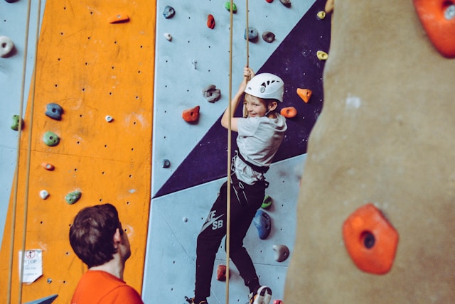 a person top roping in a climbing gym